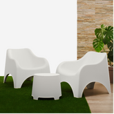 Conjunto de duas cadeiras e uma mesa IPAE PROGARDEN, em plástico, na cor branca, exibido em ambiente externo.